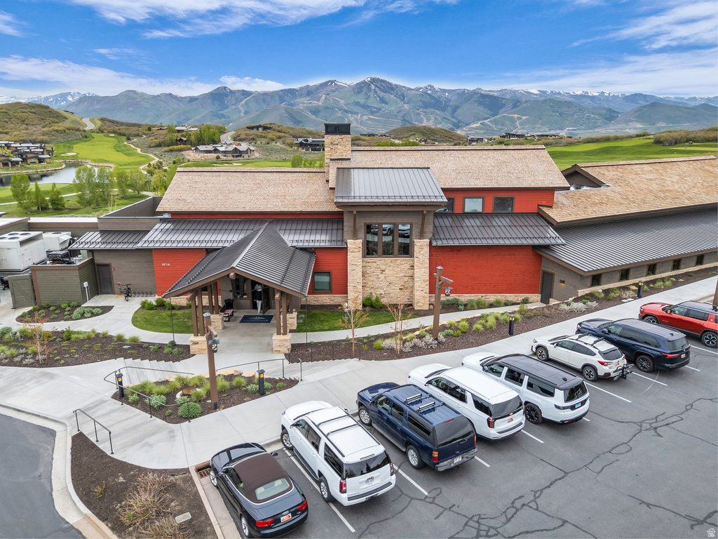 Mountain-inspired architecture featuring a stone and wood facade, covered entry, and pitched metal roofing