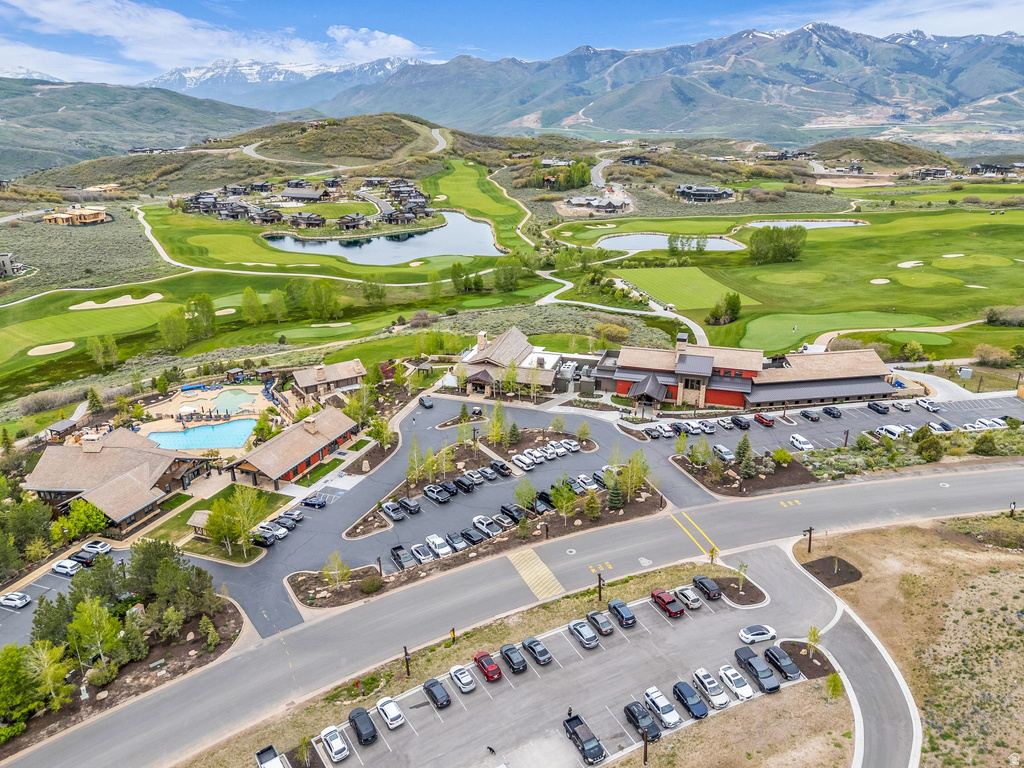 Aerial overview of a mountain community featuring multiple buildings with brown roofs, a large central parking area, and paved roadways