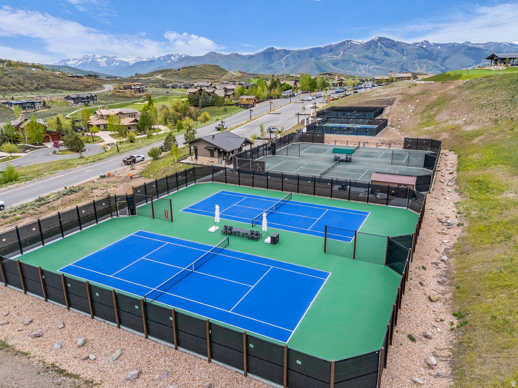 Tennis court complex featuring two blue-surfaced courts, two green-surfaced courts, and surrounding fencing