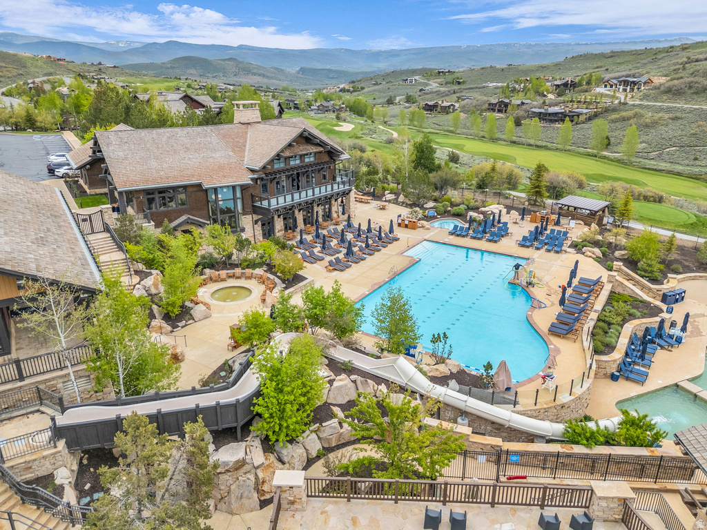 Expansive outdoor aquatic area featuring a large swimming pool, leisure pool, and water slide