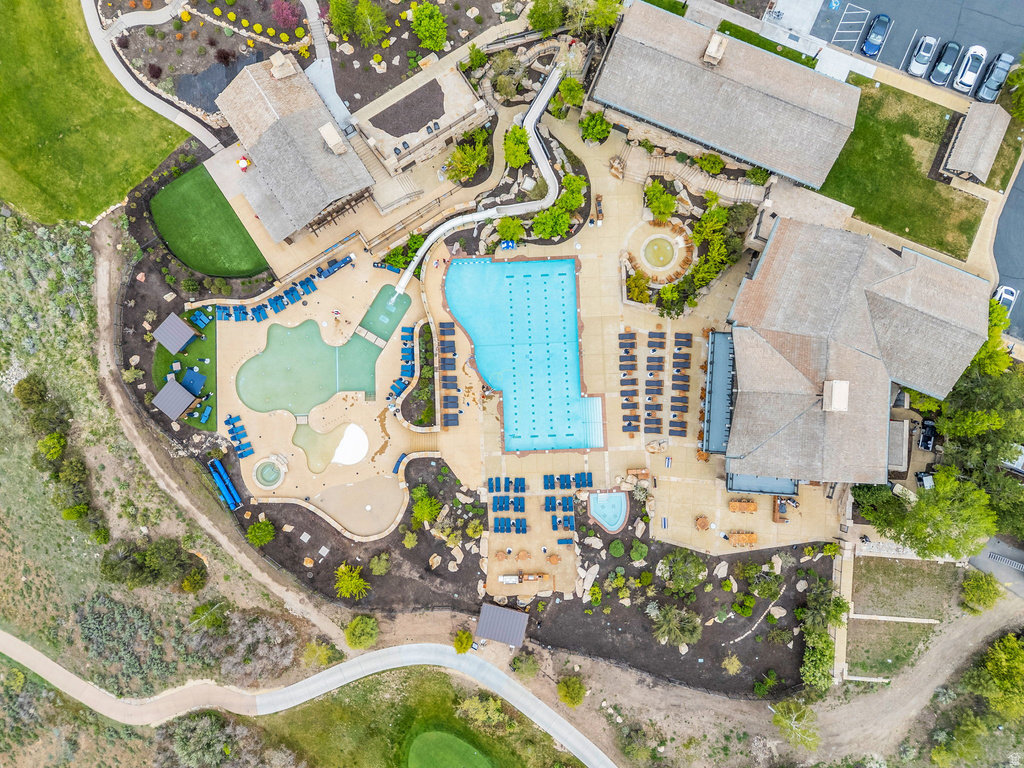 Community recreation area featuring multiple swimming pools, extensive patio decking, and surrounding landscaped grounds