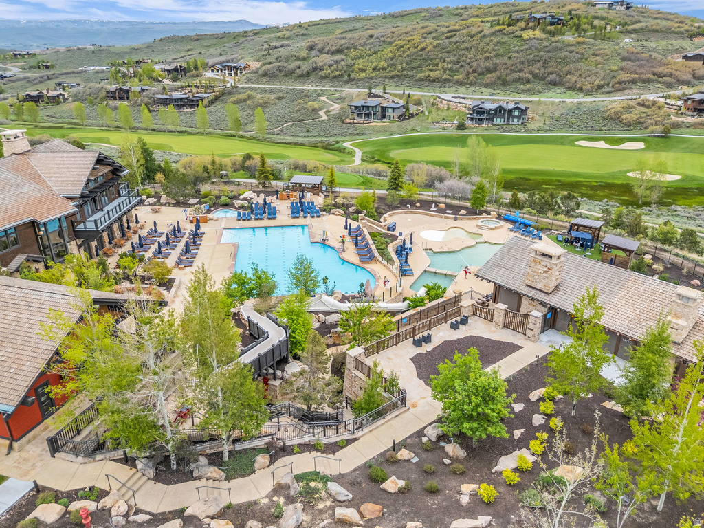 Expansive community pool area featuring a large rectangular pool, a winding leisure pool, and multiple water slides