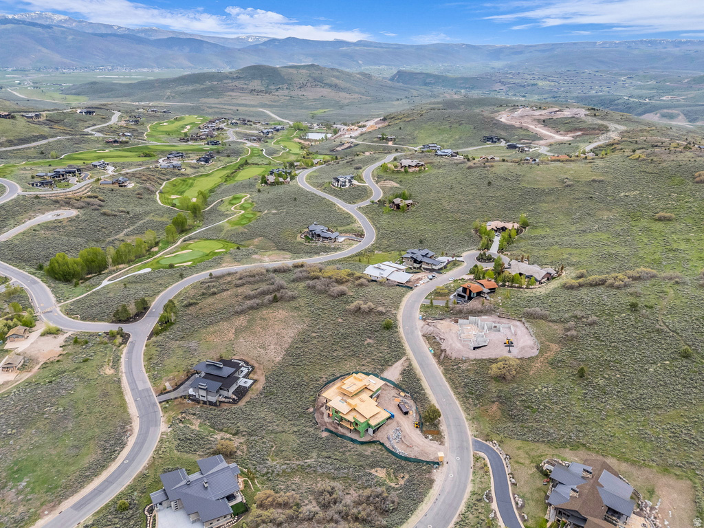 Sweeping aerial perspective showcasing a residential community amidst rolling hills and distant mountains