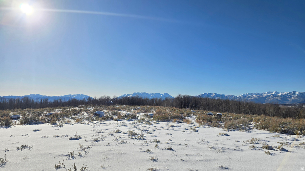 Expansive snow-covered terrain with distant mountains under a clear sky