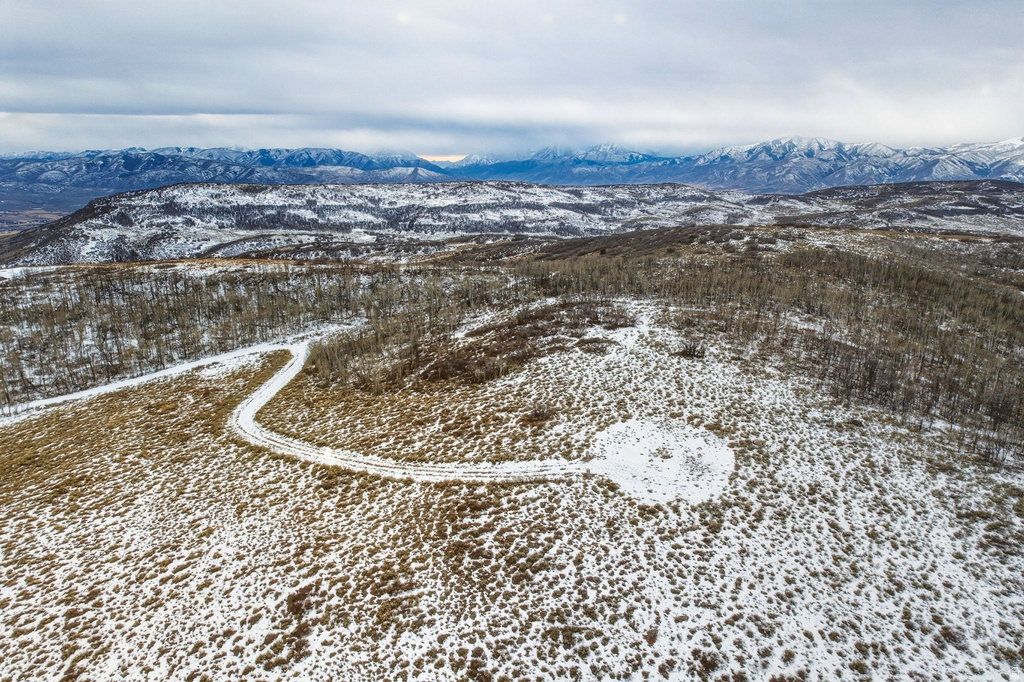 Expansive, snow-dusted landscape featuring a winding access road