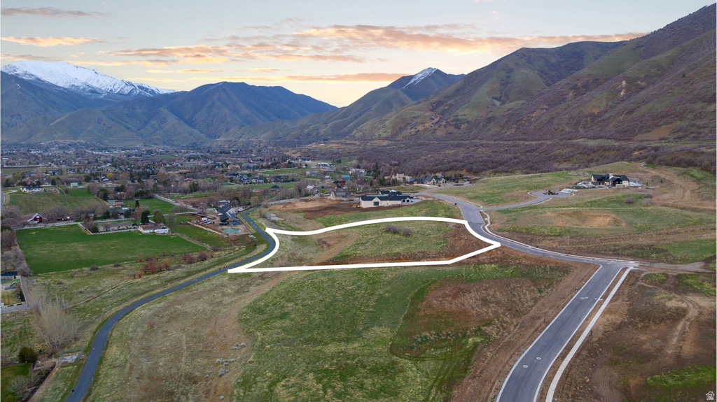 Mountain-backed residential lot featuring undeveloped land, paved road access, and scattered residential properties