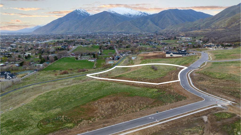 Expansive land parcel featuring a paved road frontage and surrounding natural terrain