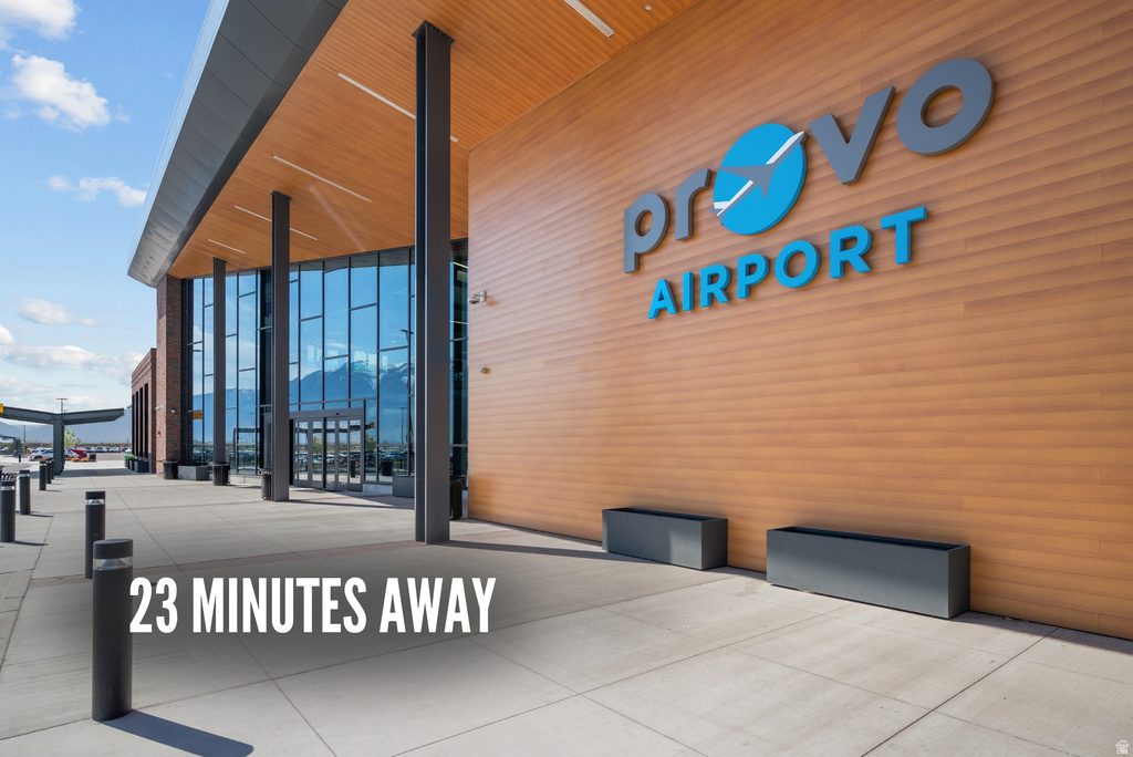 Modern airport terminal featuring extensive glass curtain walls, wood-finish paneling, and an exposed structural steel facade