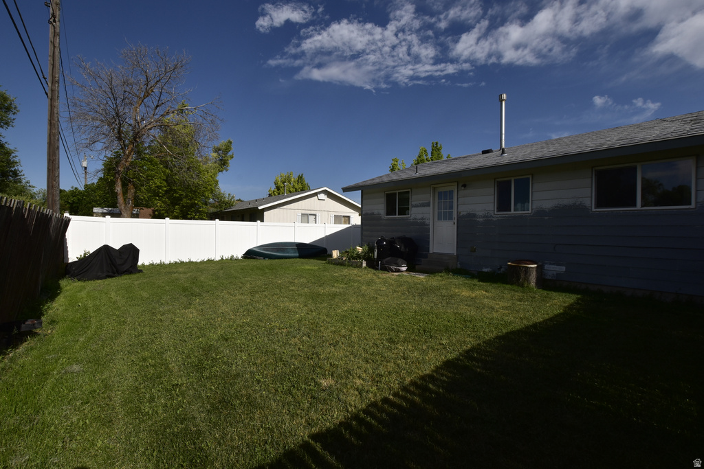 Expansive green lawn with a white privacy fence