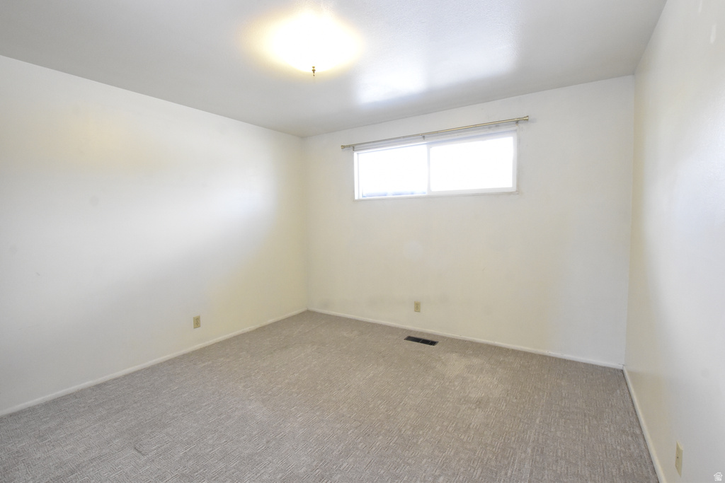 Neutral-toned carpeting paired with light-colored walls and a dual-pane window