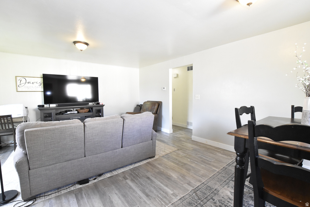 Open-concept living space featuring wood-finish flooring, recessed lighting, and crisp white walls