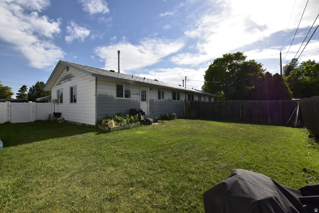 Expansive backyard featuring a manicured lawn, a full privacy fence, and a white vinyl fence section
