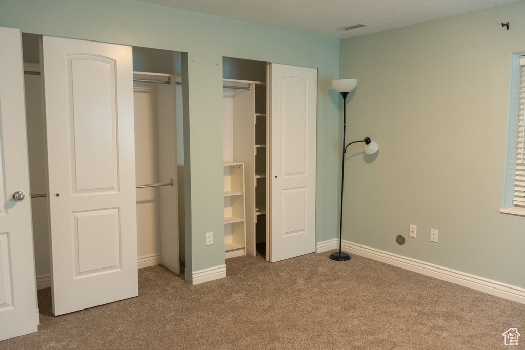 Plush carpeted flooring with baseboard trim