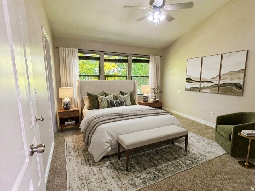 Carpeted bedroom featuring a vaulted ceiling and a ceiling fan with integrated lighting