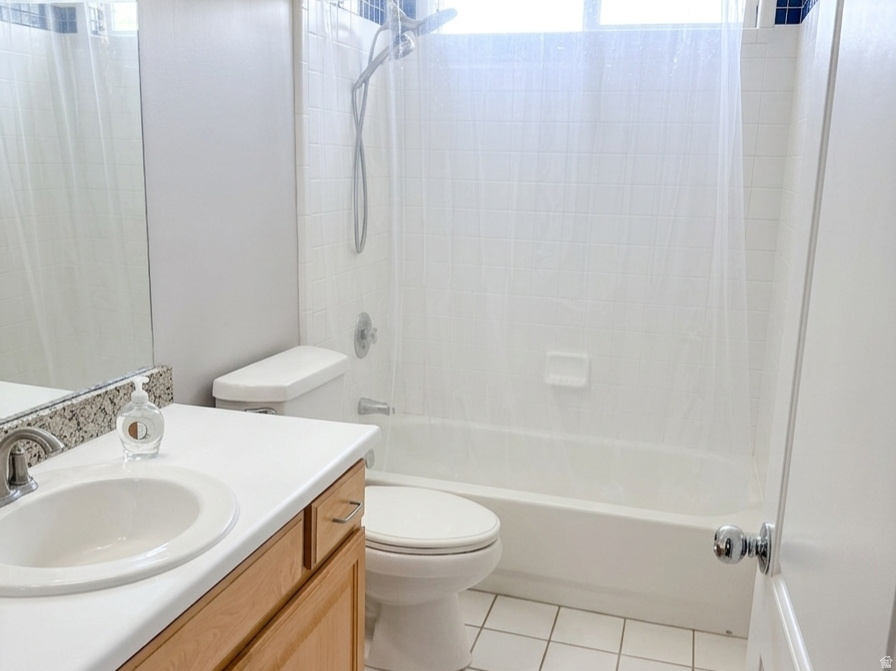 Bathroom featuring a single vanity with wood cabinetry, a white countertop, and a drop-in sink