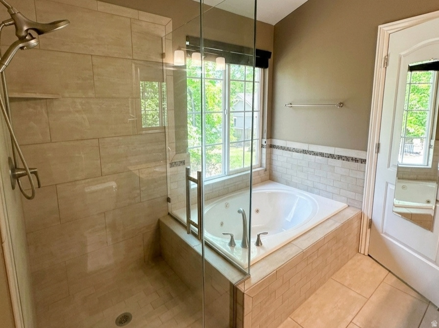 Sleek walk-in shower with glass enclosure, featuring light-toned tile surrounds and a brushed nickel showerhead