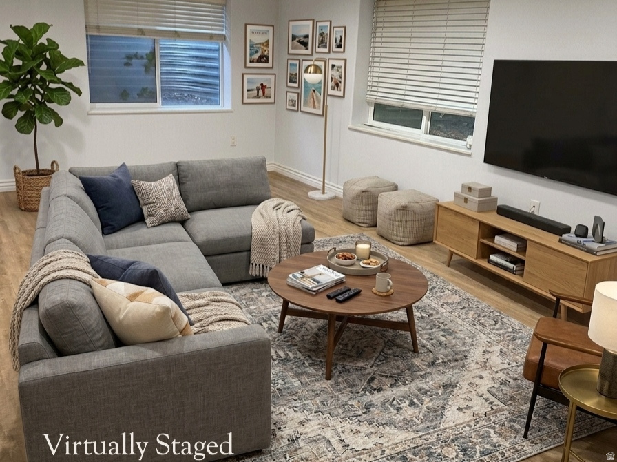 Recessed ceiling lighting illuminates this versatile living area, featuring wood-finish flooring and multiple windows with blinds