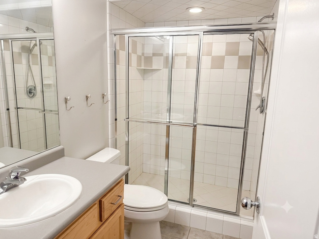 Full bathroom featuring a glass-enclosed shower with tile surround, a built-in shower niche, and a vanity with an integrated sink