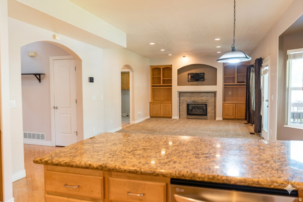 Kitchen island with a granite-style countertop and light wood cabinetry
