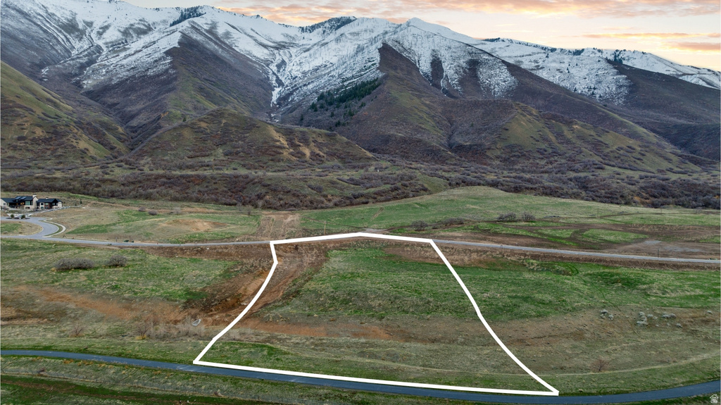 Expansive land parcel featuring natural terrain and distant snow-capped mountains