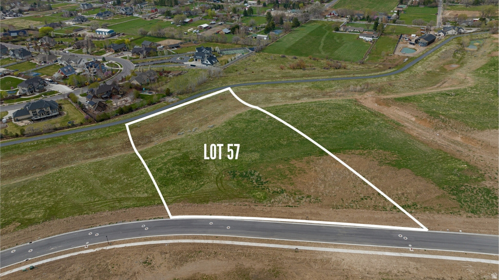 Aerial depiction of Lot 57, featuring a graded build site with partial green ground cover and direct road frontage