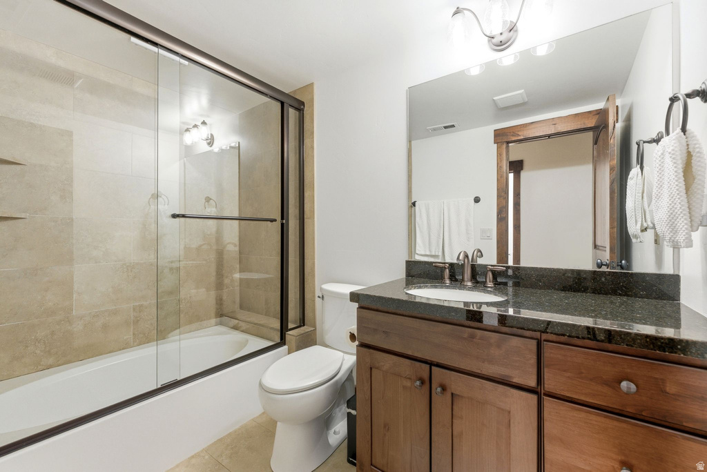 Bathroom featuring a dark wood-finish vanity with a dark speckled countertop, an undermount sink, and brushed nickel fixtures