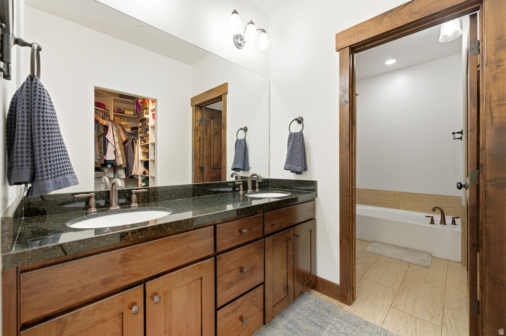 Double vanity with dark wood cabinetry and a dark stone countertop featuring dual undermount sinks