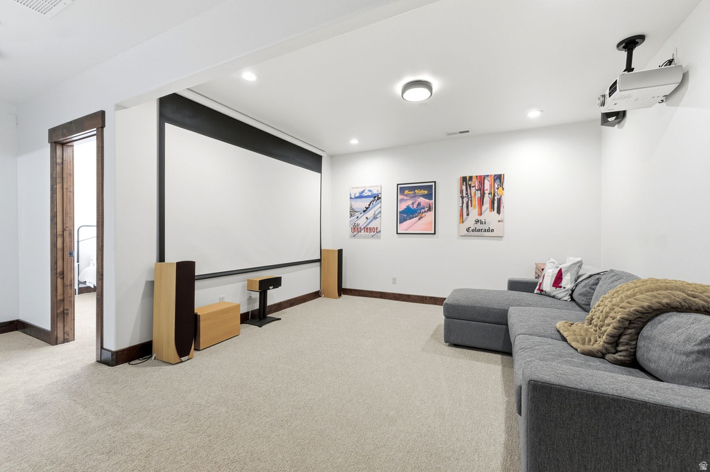Entertainment room featuring a large projection screen, recessed lighting, and soft carpet flooring