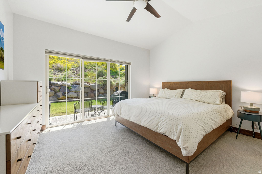 Vaulted ceiling room with large sliding glass door, direct patio access, and a ceiling fan