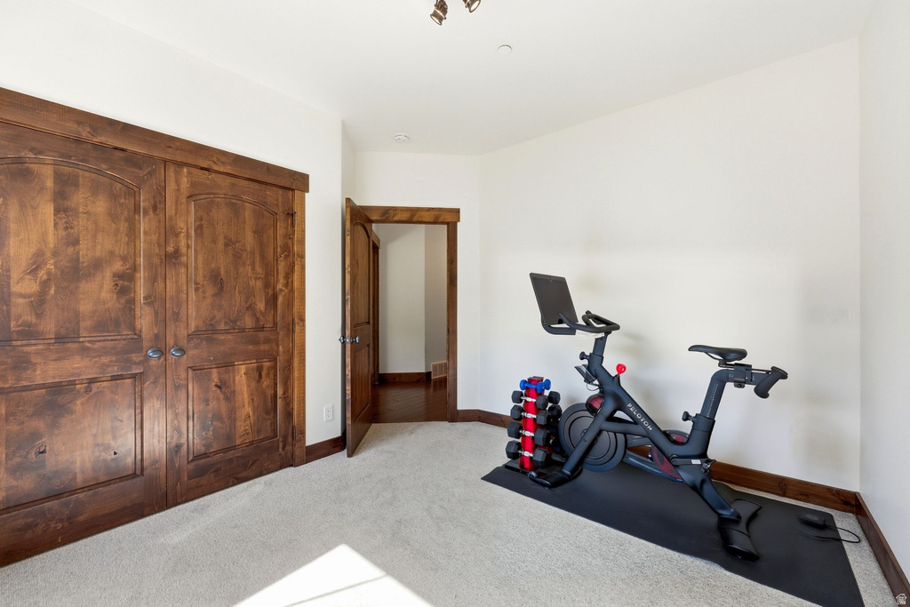 Room featuring double arched panel wood doors, an open wood doorframe, light-colored carpeting, and white walls