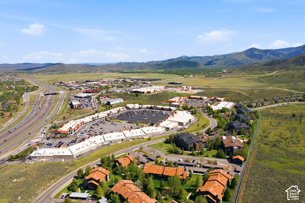 Aerial perspective showcasing a mixed-use commercial and residential district with surrounding natural landscapes
