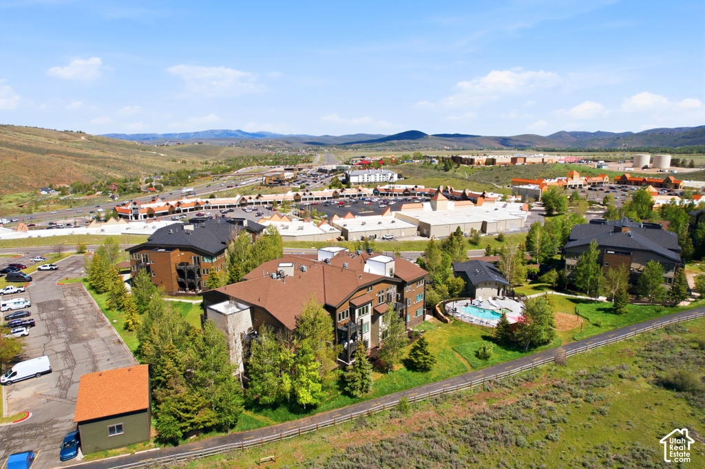 Aerial perspective showcasing multiple residential buildings, an outdoor swimming pool, and green spaces