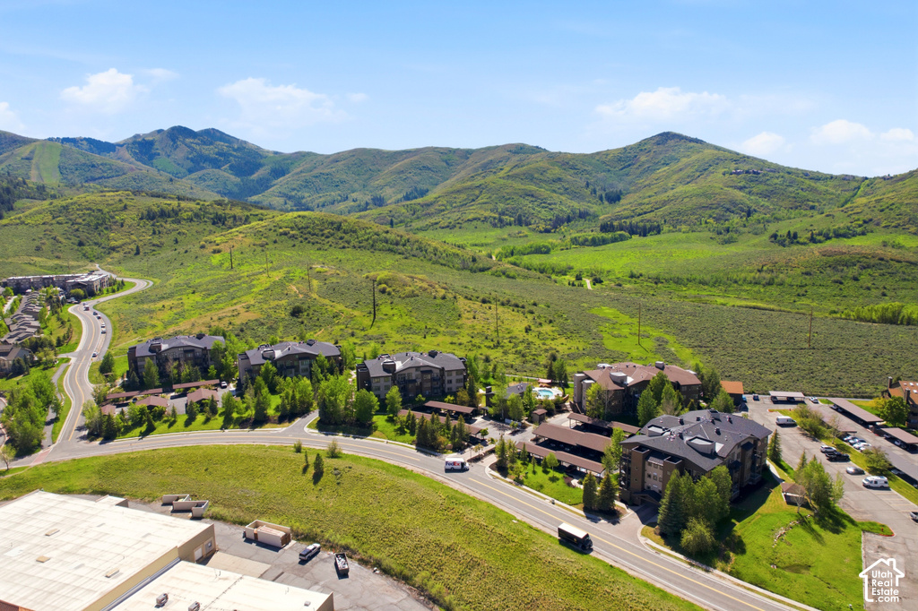 Aerial perspective showcasing multiple residential buildings nestled within a mountainous, green landscape