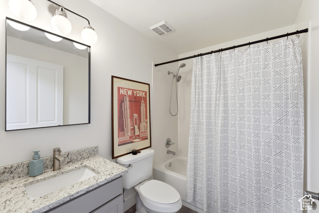 Bathroom featuring a vanity with a light-colored countertop, an undermount sink, and a chrome faucet