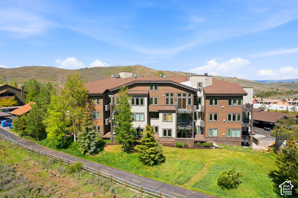 Multi-story residential building featuring a combination of wood-look siding and light-toned panels