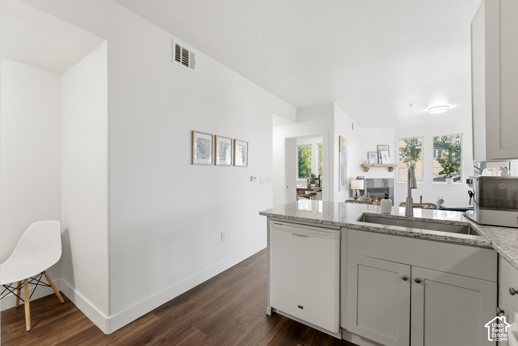 Modern kitchen featuring light grey cabinetry, a stainless steel sink with a high-arc faucet, and light-colored granite countertops