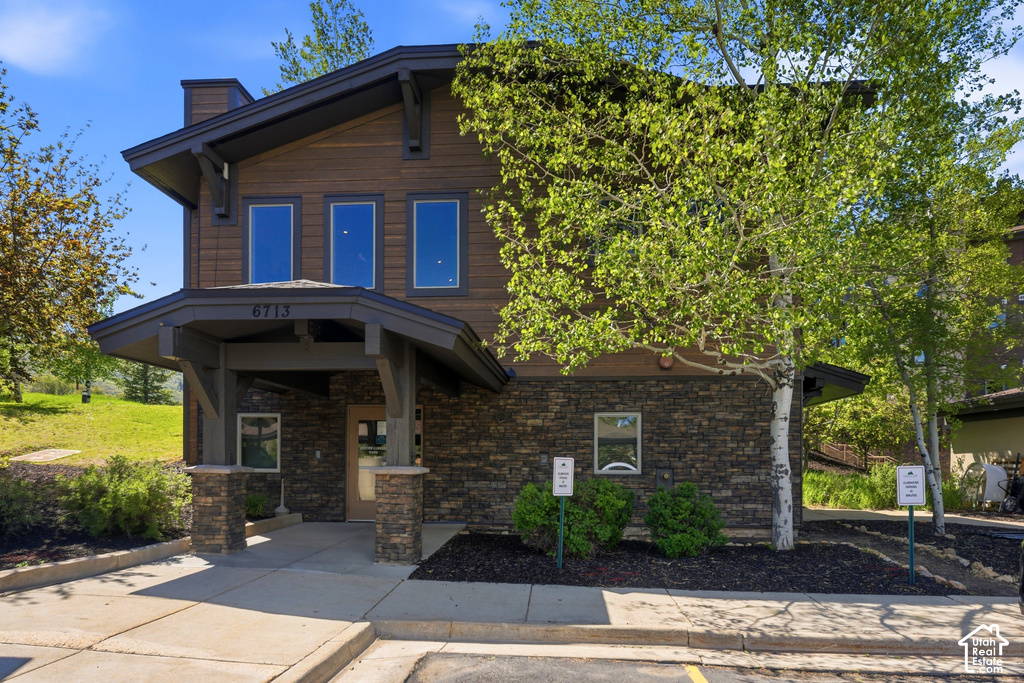 Two-story building featuring wood siding and stone veneer