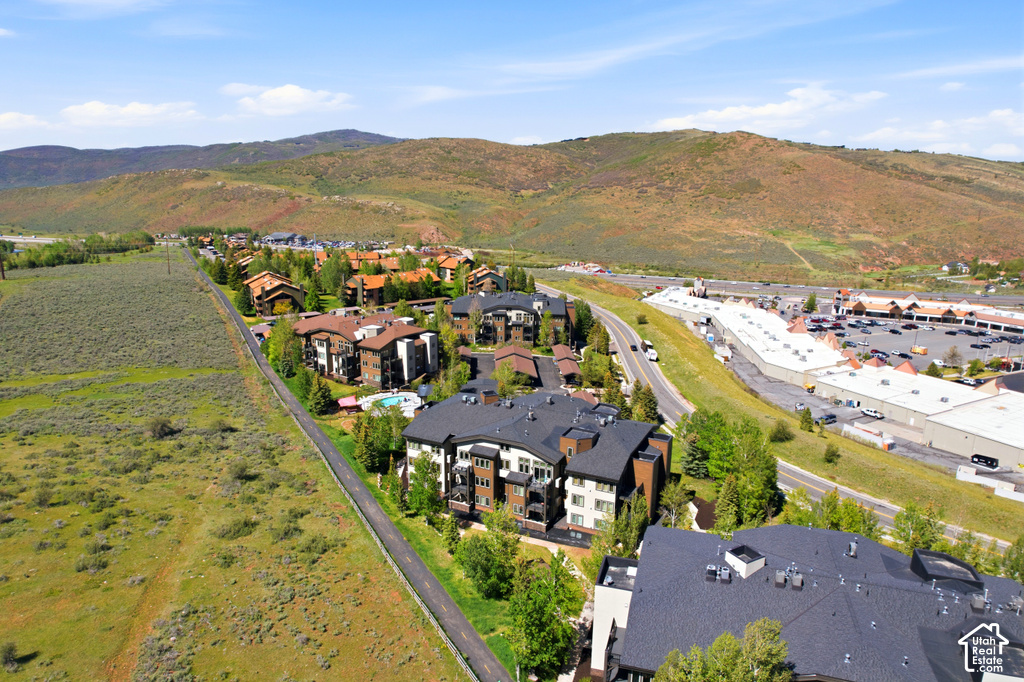Aerial perspective featuring a residential development with multi-story buildings, dark roofs, and private balconies