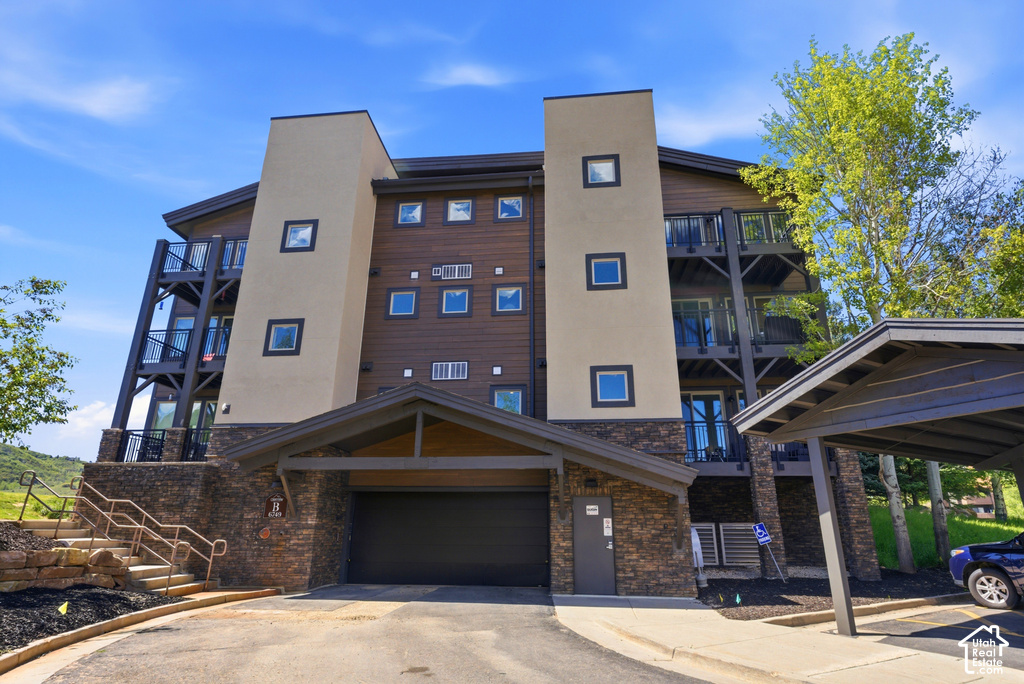 Modern multi-story building featuring stacked balconies and a covered entrance