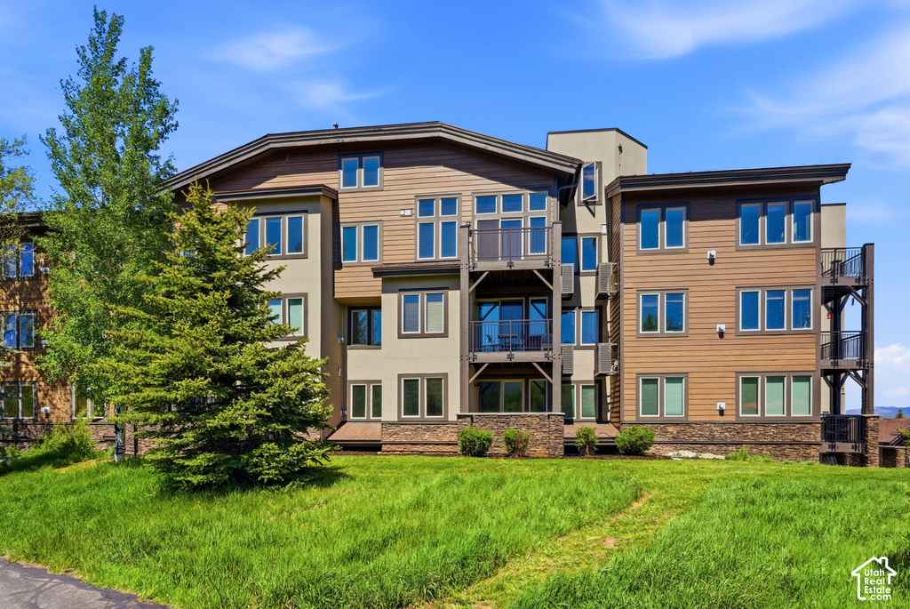 Multi-level building with mixed material facade featuring stucco and horizontal siding