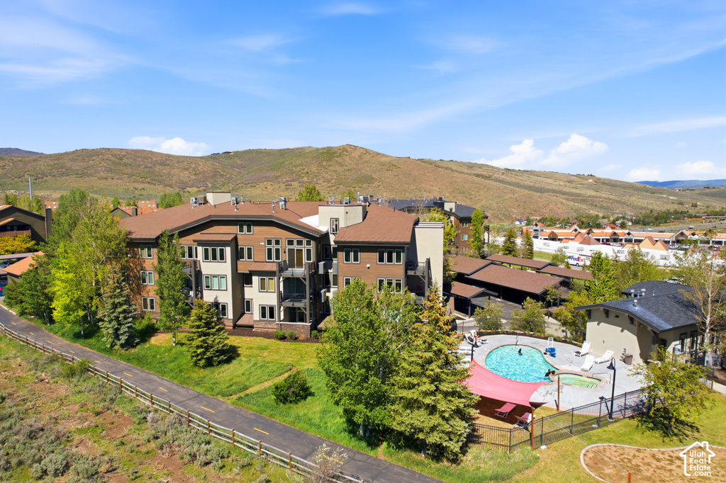 Contemporary multi-story building featuring multiple balconies and a large outdoor swimming pool