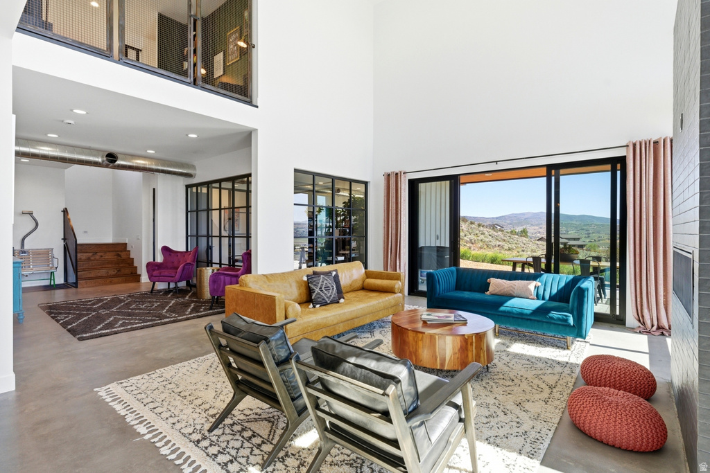 Spacious living area featuring high ceilings, concrete flooring, and a large sliding glass door