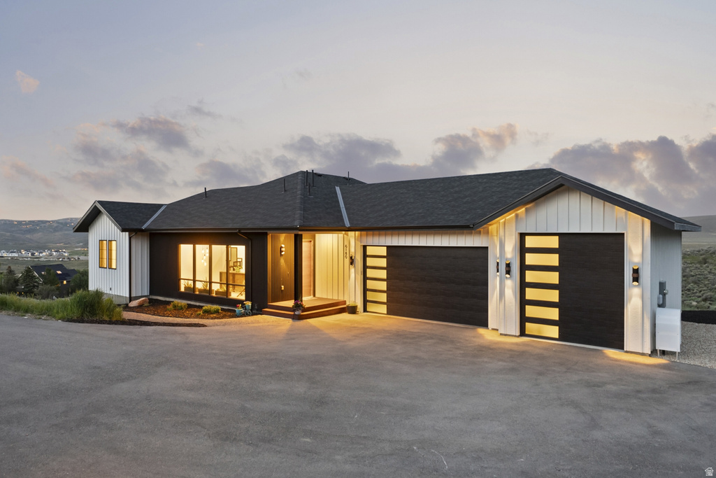 Modern ranch-style home featuring a black and white exterior with vertical siding accents