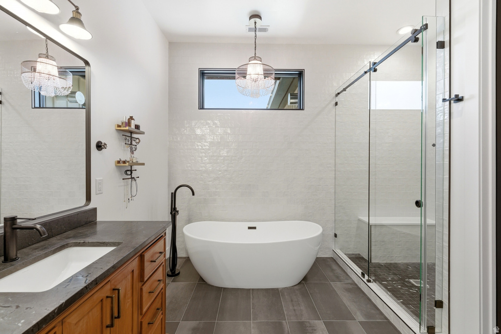 Freestanding soaking tub with a floor-mounted faucet, complemented by a glass-enclosed shower with a built-in bench