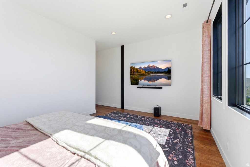 Wood-finish flooring with a modern wall-mounted television and integrated soundbar
