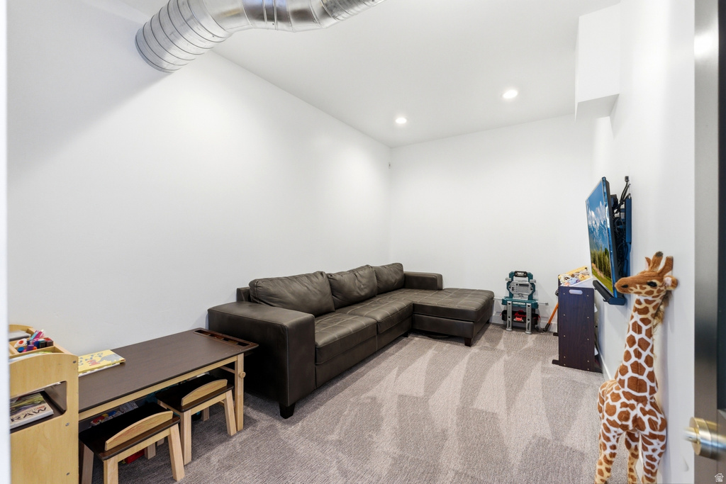 Spacious room with light-colored walls, recessed lighting, and a textured grey carpet