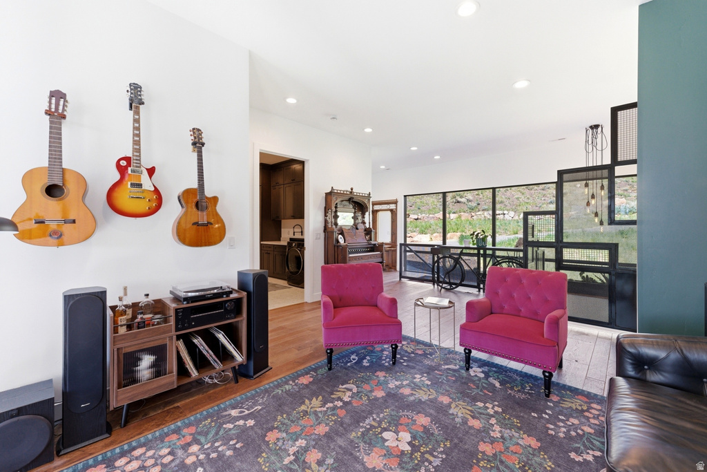 Open-concept living space featuring wood-finish flooring, recessed lighting, and a partial height wall with a decorative metal screen