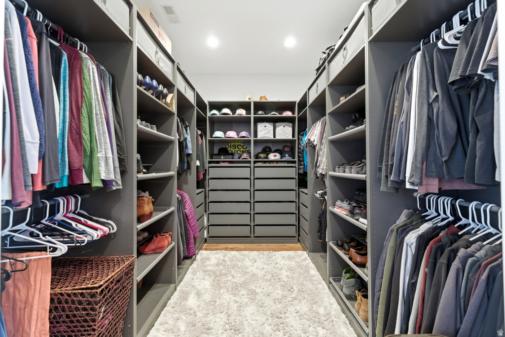 Custom closet system featuring extensive shelving, multiple hanging rods, built-in drawers, and overhead storage
