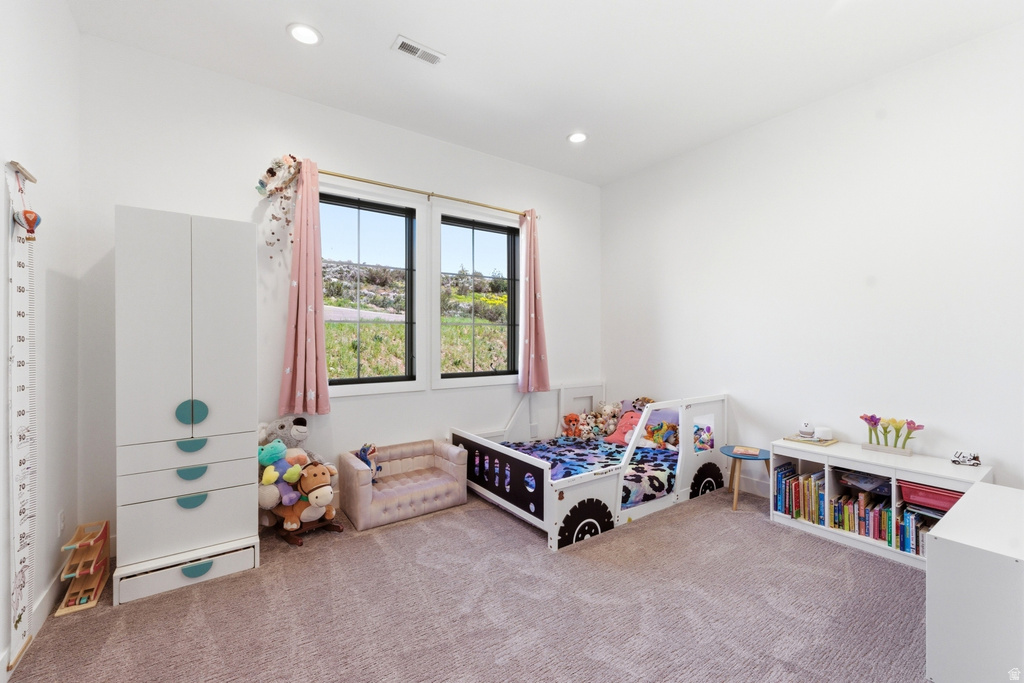 Bright room featuring two windows with dark frames, white walls, recessed ceiling lighting, and light-colored carpeting