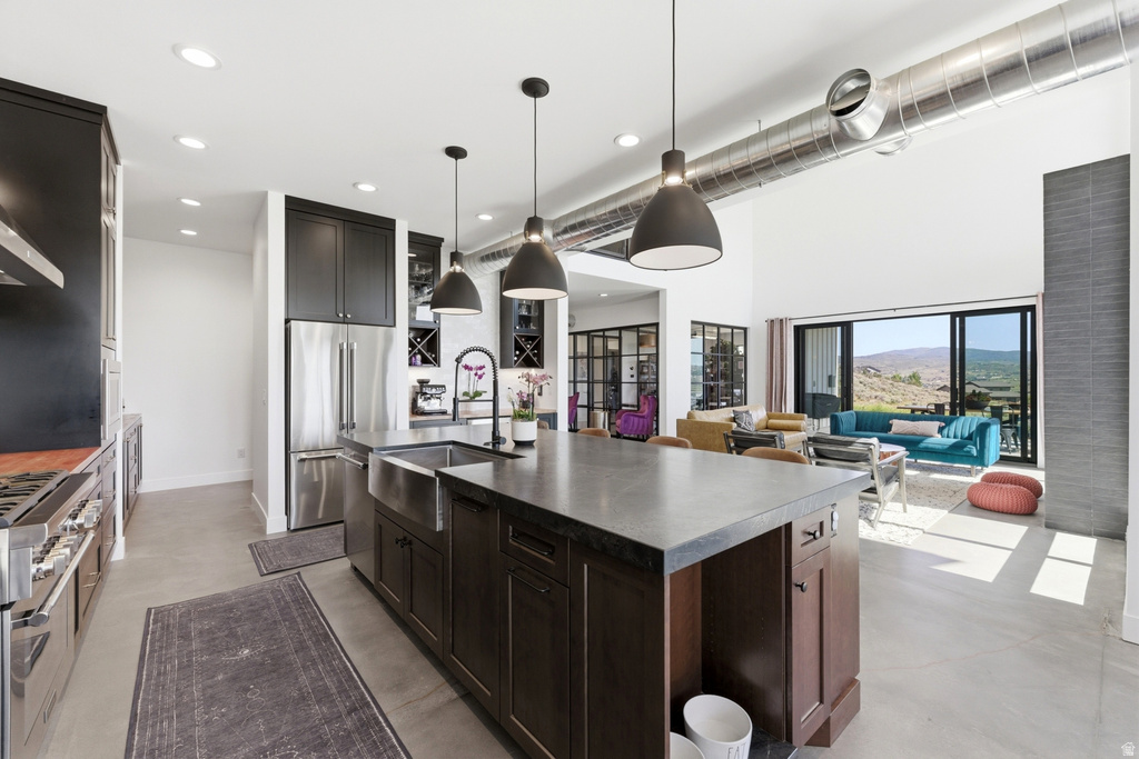 Gourmet kitchen with a large central island, stainless steel appliances, and dark cabinetry